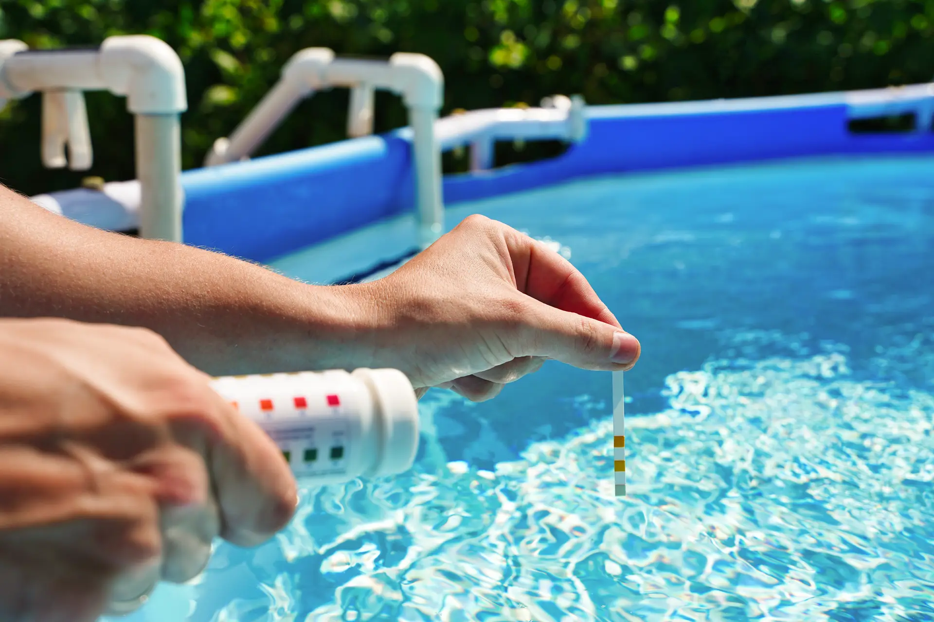 Pool technician testing swimming pool water pH and chemical balance